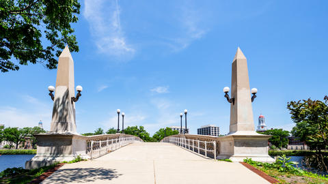 Looking across a stone pedestrian bridge with tall, pointed columns on either side