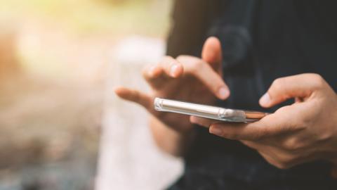 Close-up of a person's hands dialing a cell phone