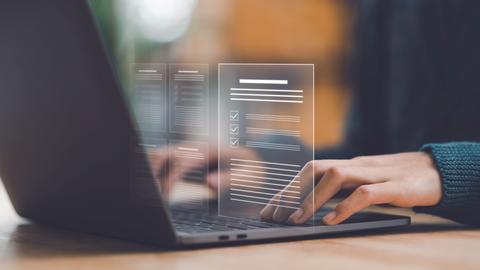A close-up view of a person's hands working on a laptop