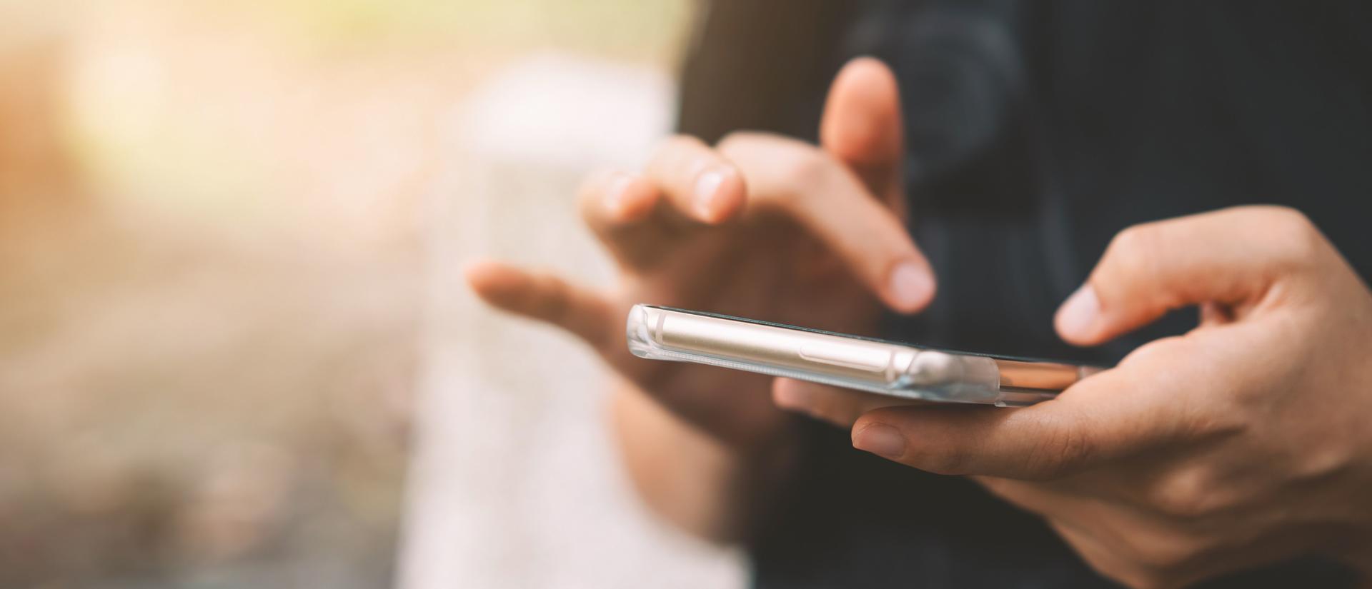 Close-up of a person's hands dialing a cell phone